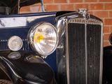 a close up of a vintage car with a brick wall in the background