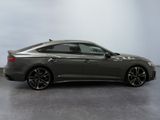 a gray car is parked in a room with a white wall