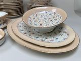 many plates and bowls sitting on a table together