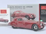 une maquette rouge d'une voiture à côté d'une boîte emballée