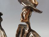 bronze figurine of a man and a woman holding hands