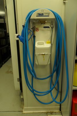 un tuyau bleu raccordé à des toilettes blanches dans une pièce