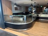 a curved glass counter in the middle of a store