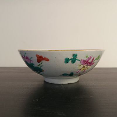 bowl on a table with flowers painted on the side of it