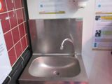 a stainless steel sink in a public restroom