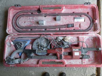 une mallette rouge contenant des outils, posée par terre