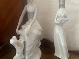 two figurines of a woman and a child on a table