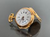 a gold pocket watch with roman numerals on it
