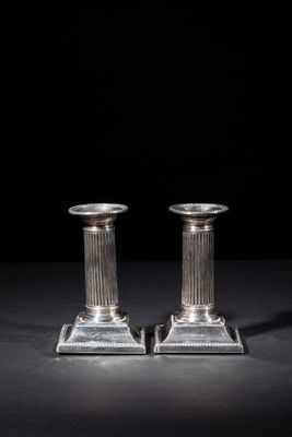 a pair of silver candlesticks on a black background