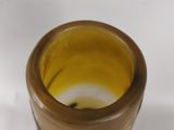 a small glass vase with a brown and yellow design on it