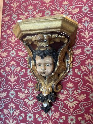 a picture of a wall sconce with a child ' s head on it