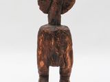 an old wooden statue of a man with a hat on his head