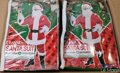 deux sacs contenant un costume de Père Noël posés sur une table