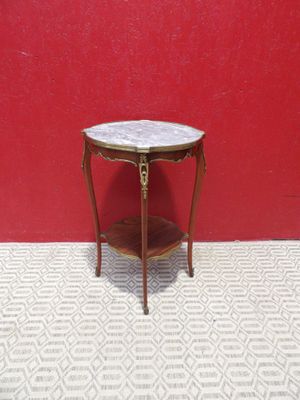 une petite table avec un plateau en marbre devant un mur rouge
