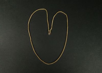 un collier avec une chaîne en or sur fond noir