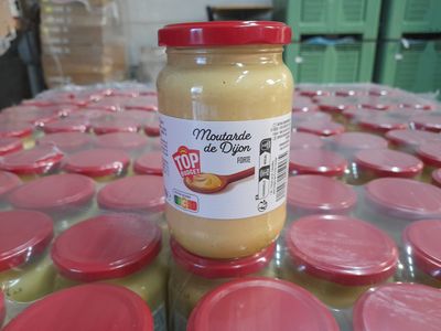 a jar of mustard sitting on top of a table