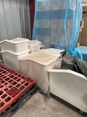 de nombreux cartons et bacs posés par terre