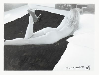 black and white photograph of a naked woman laying on a bed
