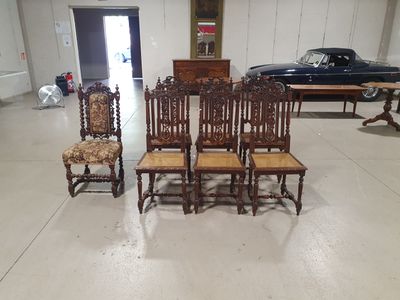 quatre chaises et une table dans une pièce, avec une voiture en arrière-plan