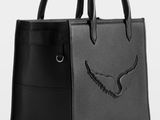 a black leather handbag with an eagle design on the front