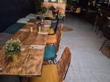 une longue table entourée de nombreuses chaises et tables dans la pièce