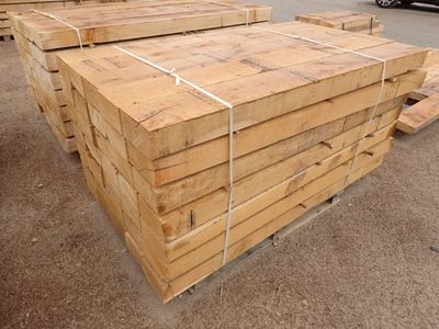 de nombreuses pièces de bois empilées les unes sur les autres dans un parking