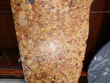 a marble vase sitting on the floor next to a wooden cabinet
