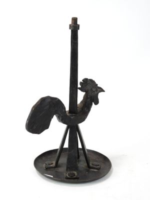 a black rooster statue on a stand on a white background