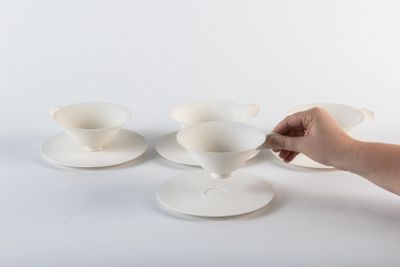 une personne qui tient une cuillère et quelques tasses