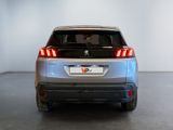 the rear end of a silver car with its tail lights on