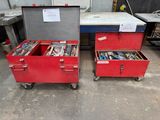 deux boîtes rouges contenant des outils, posées par terre