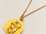 un gros plan sur un collier en or orné d'un bébé