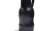 un vase noir posé sur une surface blanche