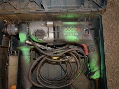 a drill in a tool box with a cord in it
