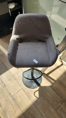 a grey chair that is sitting on a wooden floor