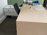 a desk with a chair and a lamp in the corner of the room
