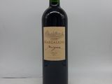 une bouteille de vin rouge posée sur une table blanche