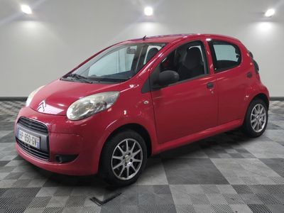 la petite voiture rouge est garée sur un sol en damier