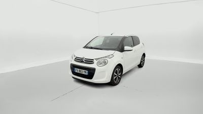 une petite voiture blanche est garée dans une pièce blanche