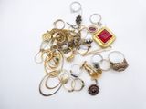 a pile of gold and silver jewelry on a white surface