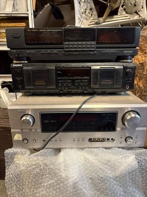 trois chaînes hi-fi empilées les unes sur les autres dans une pièce