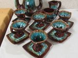 many pieces of pottery sitting on a white table