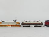 several toy trains are lined up in a row on a white surface