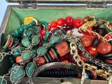 a box filled with assorted jewelry and a hair comb