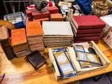 beaucoup de livres posés sur une table où se trouvent déjà beaucoup d'autres livres