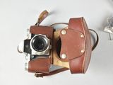 a small camera with a leather case on it