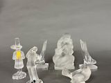 three clear glass figurines are sitting on a gray surface