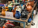 de nombreux vases de toutes sortes posés sur une table dans une pièce
