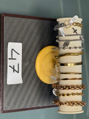 une pile de bracelets et une boîte sur laquelle est accrochée une étiquette