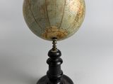an old globe on a black stand with a white background